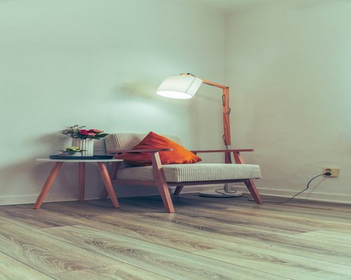 A well-lit cozy reading corner with a lamp and natural light
